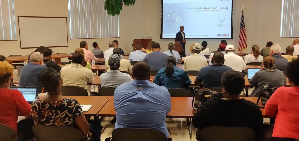Audience attending a cybersecurity awareness training session with a presenter at the front of the room