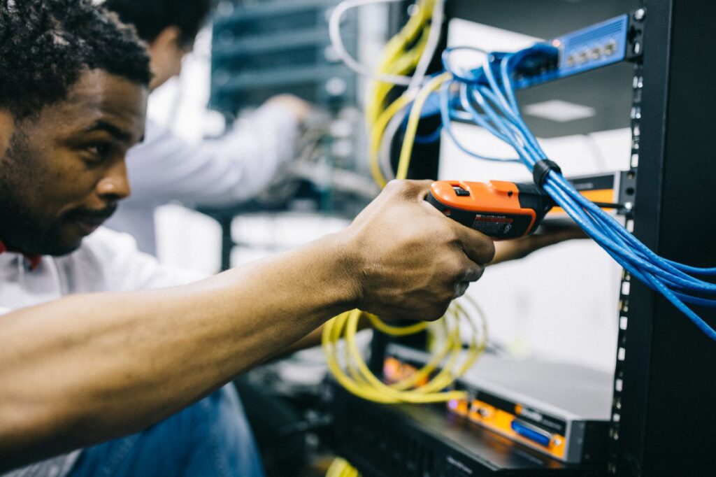 Network engineer testing cables on a server rack